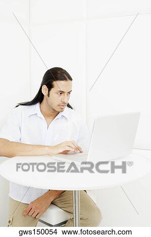 Young man using a laptop View Large Photo Image Picture - Young man using a laptop. Fotosearch