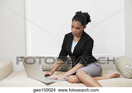 Picture - Young woman using a laptop. Fotosearch