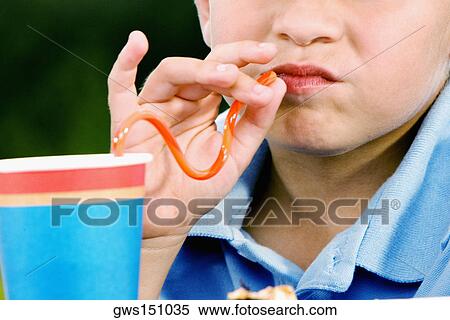 Close-up of a boy drinking with a straw View Large Photo Image Stock Photography - Close-up of a boy drinking with a straw. Fotosearch