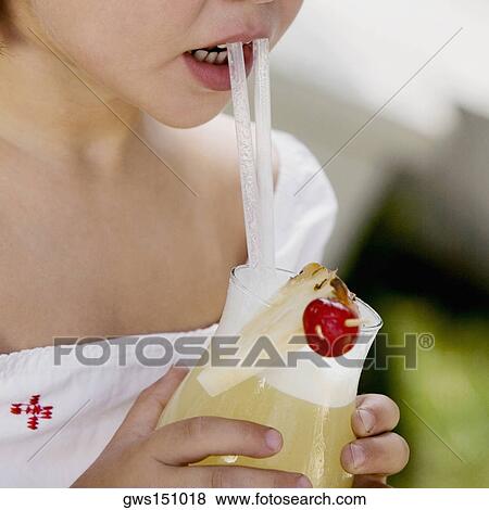 Close-up of a girl drinking pineapple juice with a straw View Large Photo Image Stock Photo - Close-up of a girl drinking pineapple juice with a straw. Fotosearch