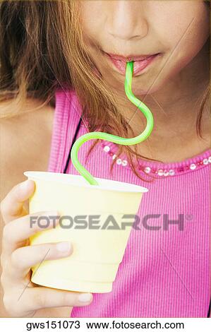 Stock Image - Close-up of a girl drinking with a straw. Fotosearch