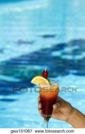 Close-up of a person's hand holding a glass of cocktail View Large Photo Image Stock Photo - Close-up of a person's hand holding a glass of cocktail. Fotosearch