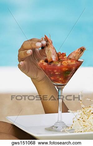 Close-up of a person's hand picking up a shrimp from a shrimp cocktail View Large Photo Image Stock Photo - Close-up of a person's hand picking up a shrimp from a shrimp cocktail. Fotosearch