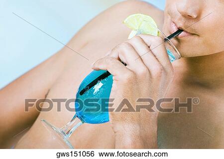 Close-up of a young man drinking a glass of cocktail View Large Photo Image Stock Photograph - Close-up of a young man drinking a glass of cocktail. Fotosearch