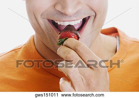 Close-up of a young man eating a strawberry View Large Photo Image Stock Image - Close-up of a young man eating a strawberry. Fotosearch