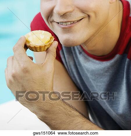 Close-up of a young man holing a lime tart View Large Photo Image Picture - Close-up of a young man holing a lime tart. Fotosearch