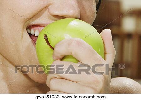 Close-up of a young woman eating a green apple View Large Photo Image Stock Image - Close-up of a young woman eating a green apple. Fotosearch