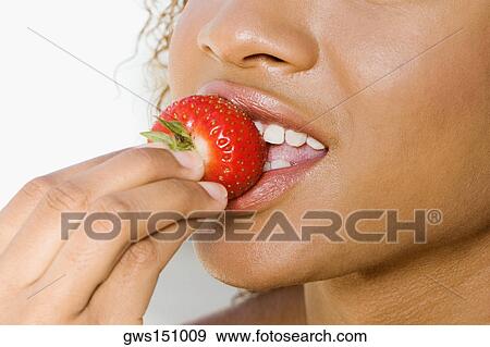 Close-up of a young woman eating a strawberry View Large Photo Image Stock Photo - Close-up of a young woman eating a strawberry. Fotosearch