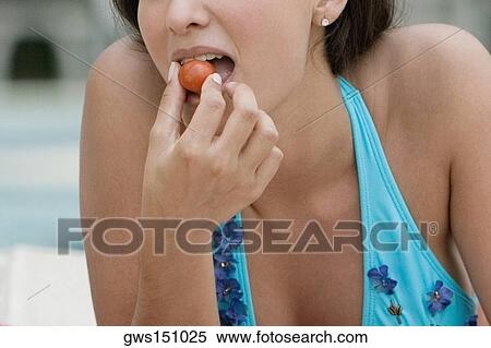 Close-up of a young woman eating a cherry tomato View Large Photo Image Stock Photography - Close-up of a young woman eating a cherry tomato. Fotosearch