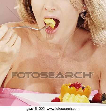 Close-up of a young woman eating fruit salad with a fork View Large Photo Image Stock Image - Close-up of a young woman eating fruit salad with a fork. Fotosearch