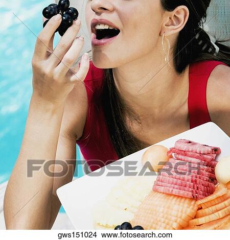 Close-up of a young woman eating red grapes View Large Photo Image Picture - Close-up of a young woman eating red grapes. Fotosearch