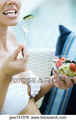 Close-up of a young woman eating salad with a fork View Large Photo Image Stock Photograph - Close-up of a young woman eating salad with a fork. Fotosearch