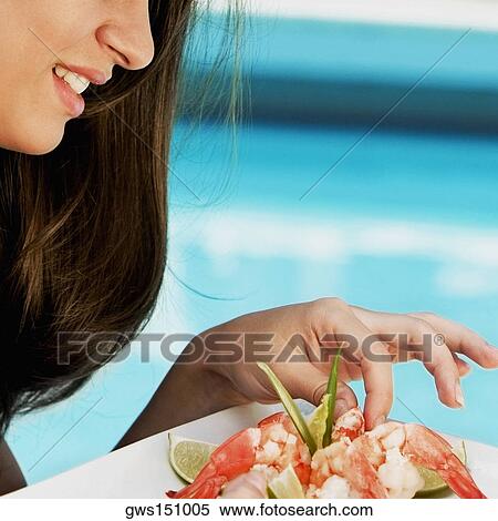 Close-up of a young woman eating shrimp View Large Photo Image Stock Photography - Close-up of a young woman eating shrimp. Fotosearch
