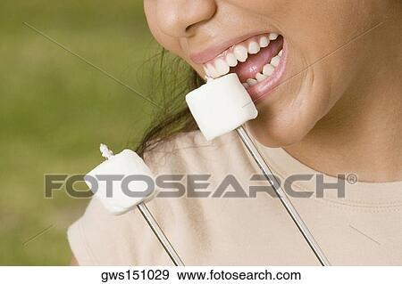 Close-up of a young woman eating marshmallows View Large Photo Image Stock Photo - Close-up of a young woman eating marshmallows. Fotosearch