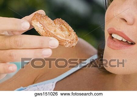 Close-up of a young woman holding a heart shaped cookie View Large Photo Image Stock Photograph - Close-up of a young woman holding a heart shaped cookie. Fotosearch