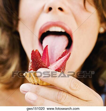 Close-up of a young woman licking a strawberry tart View Large Photo Image Stock Image - Close-up of a young woman licking a strawberry tart. Fotosearch