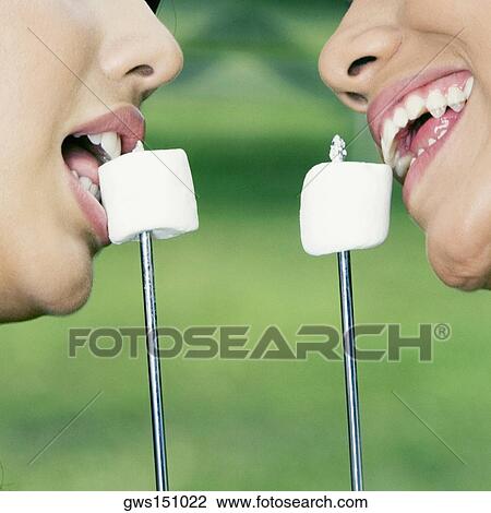 Close-up of two young women eating marshmallows View Large Photo Image Stock Image - Close-up of two young women eating marshmallows. Fotosearch