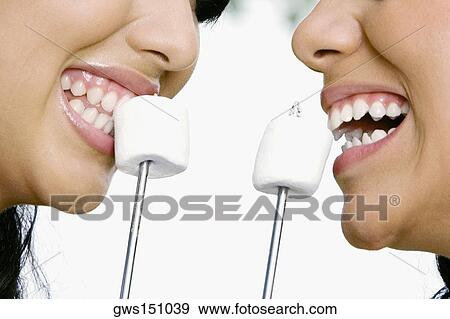 Close-up of two young women eating marshmallows View Large Photo Image Stock Photo - Close-up of two young women eating marshmallows. Fotosearch