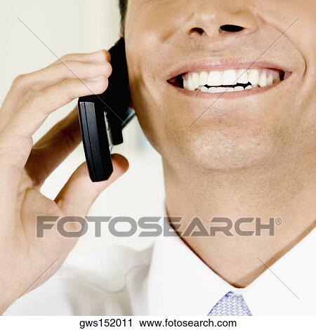 Close-up of a businessman talking on a mobile phone and smiling View Large Photo Image Stock Image - Close-up of a businessman talking on a mobile phone and smiling. Fotosearch
