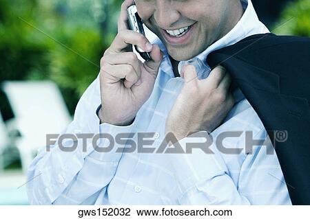 Close-up of a businessman talking on a mobile phone and smiling View Large Photo Image Stock Image - Close-up of a businessman talking on a mobile phone and smiling. Fotosearch