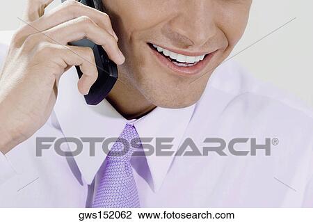 Close-up of a businessman talking on a mobile phone and smiling View Large Photo Image Stock Image - Close-up of a businessman talking on a mobile phone and smiling. Fotosearch