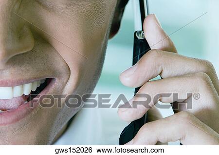 Stock Photograph - Close-up of a businessman talking on a mobile phone. Fotosearch