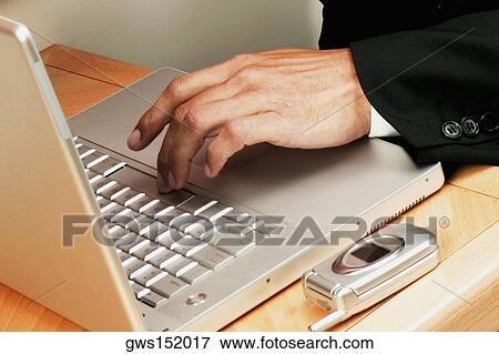 Close-up of a businessman's hand using a laptop View Large Photo Image Stock Photo - Close-up of a businessman's hand using a laptop. Fotosearch
