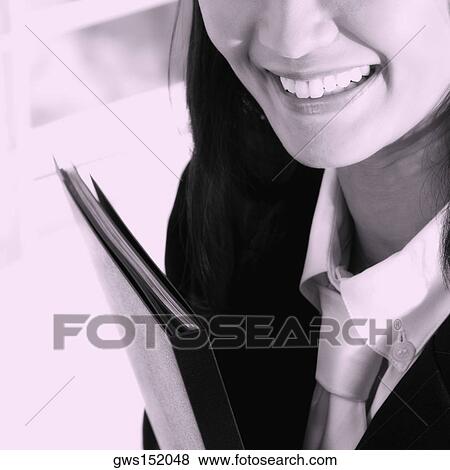 Close-up of a businesswoman holding a file and smiling View Large Photo Image Stock Photo - Close-up of a businesswoman holding a file and smiling. Fotosearch