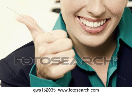 Close-up of a businesswoman showing thumbs up sign and smiling View Large Photo Image Stock Photography - Close-up of a businesswoman showing thumbs up sign and smiling. Fotosearch