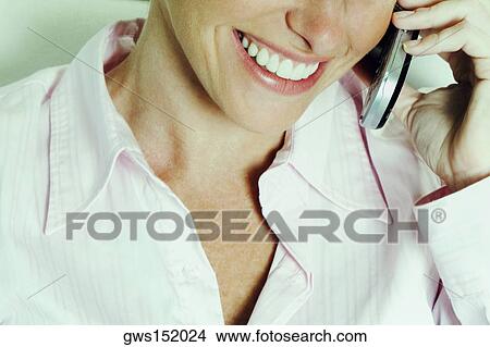 Close-up of a businesswoman talking on a mobile phone and smiling View Large Photo Image Picture - Close-up of a businesswoman talking on a mobile phone and smiling. Fotosearch