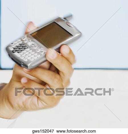 Close-up of a man's hand holding a mobile phone View Large Photo Image Stock Photo - Close-up of a man's hand holding a mobile phone. Fotosearch