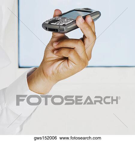 Stock Photograph - Close-up of a man's hand holding a mobile phone. Fotosearch
