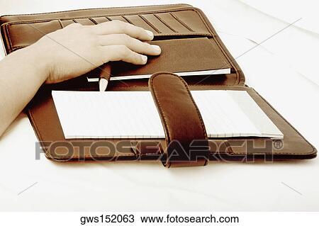 Close-up of a person's hand on a personal organizer View Large Photo Image Stock Image - Close-up of a person's hand on a personal organizer. Fotosearch