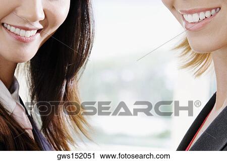 Close-up of two businesswomen smiling View Large Photo Image Stock Image - Close-up of two businesswomen smiling. Fotosearch