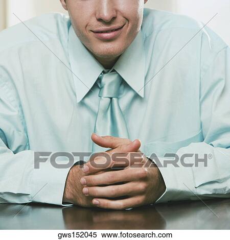 Mid section view of a businessman seated at the table and smiling View Large Photo Image Stock Photography - Mid section view of a businessman seated at the table and smiling. Fotosearch