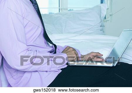 Mid section view of a businessman using a laptop View Large Photo Image Stock Photo - Mid section view of a businessman using a laptop. Fotosearch