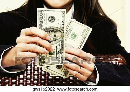 Mid section view of a businesswoman holding dollar bills View Large Photo Image Stock Image - Mid section view of a businesswoman holding dollar bills. Fotosearch