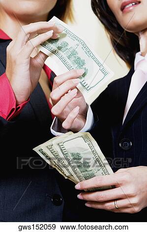 Mid section view of a businesswoman giving one hundred dollar bill to another businesswoman View Large Photo Image Stock Photo - Mid section view of a businesswoman giving one hundred dollar bill to another businesswoman. Fotosearch