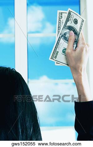 Rear view of a businesswoman holding dollar bills View Large Photo Image Stock Photography - Rear view of a businesswoman holding dollar bills. Fotosearch