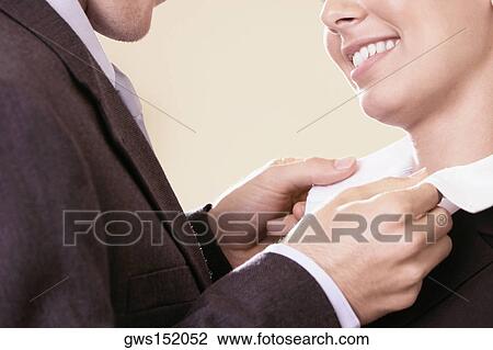 Side profile of a businessman adjusting a businesswoman's collar View Large Photo Image Stock Image - Side profile of a businessman adjusting a businesswoman's collar. Fotosearch