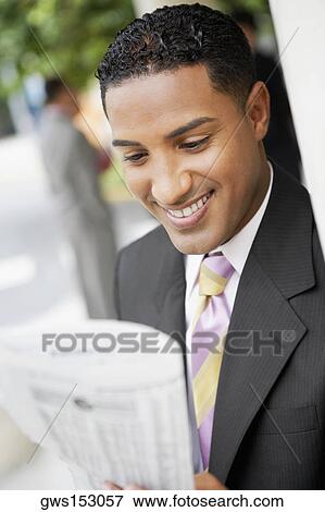 Close-up of a businessman reading a newspaper and smiling View Large Photo Image Stock Photo - Close-up of a businessman reading a newspaper and smiling. Fotosearch