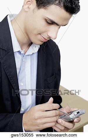 Close-up of a businessman using a personal data assistant View Large Photo Image Stock Photography - Close-up of a businessman using a personal data assistant. Fotosearch