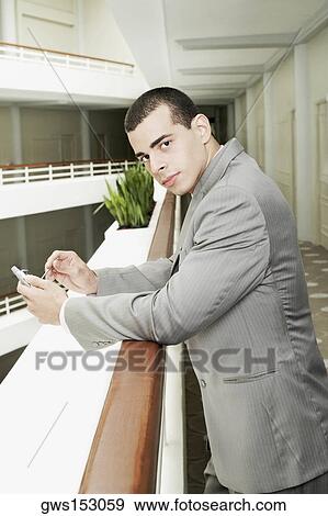 Stock Photo - Portrait of a businessman holding a personal data assistant. Fotosearch