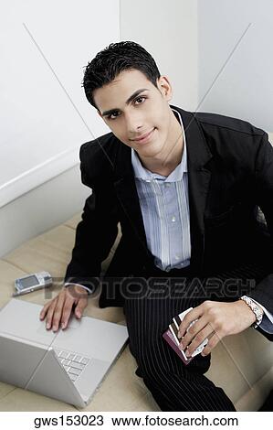 Portrait of a businessman sitting on a couch with a laptop View Large Photo Image Stock Image - Portrait of a businessman sitting on a couch with a laptop. Fotosearch