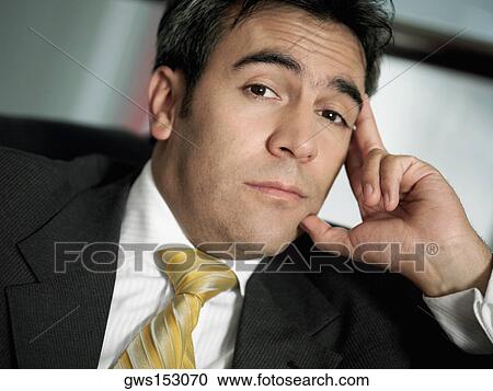 Stock Image - Portrait of a businessman with his head in his hand. Fotosearch