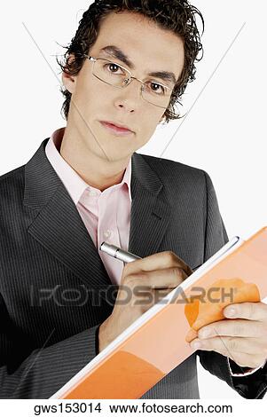 Picture - Portrait of a businessman writing on a clipboard. Fotosearch