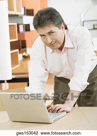 Portrait of a mature man using a laptop View Large Photo Image Stock Image - Portrait of a mature man using a laptop. Fotosearch