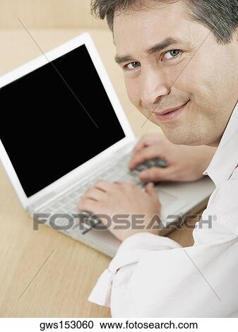 Portrait of a mature man using a laptop View Large Photo Image Stock Image - Portrait of a mature man using a laptop. Fotosearch