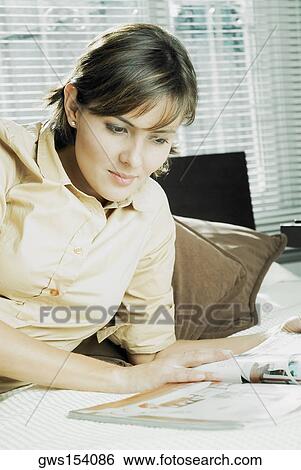 Close-up of a mid adult woman reading a magazine View Large Photo Image Stock Photograph - Close-up of a mid adult woman reading a magazine. Fotosearch