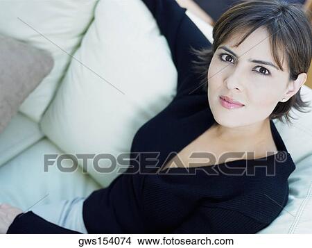 Portrait of a businesswoman sitting on a couch View Large Photo Image Picture - Portrait of a businesswoman sitting on a couch. Fotosearch